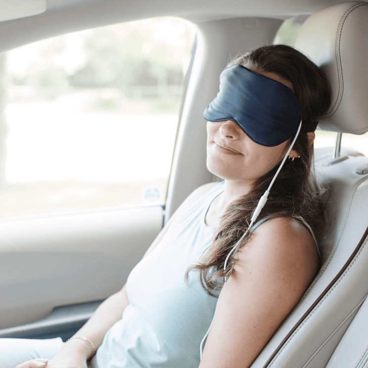 Woman wearing Comfylids Heated Eye Mask SILK in car for dry eye relief and relaxation.